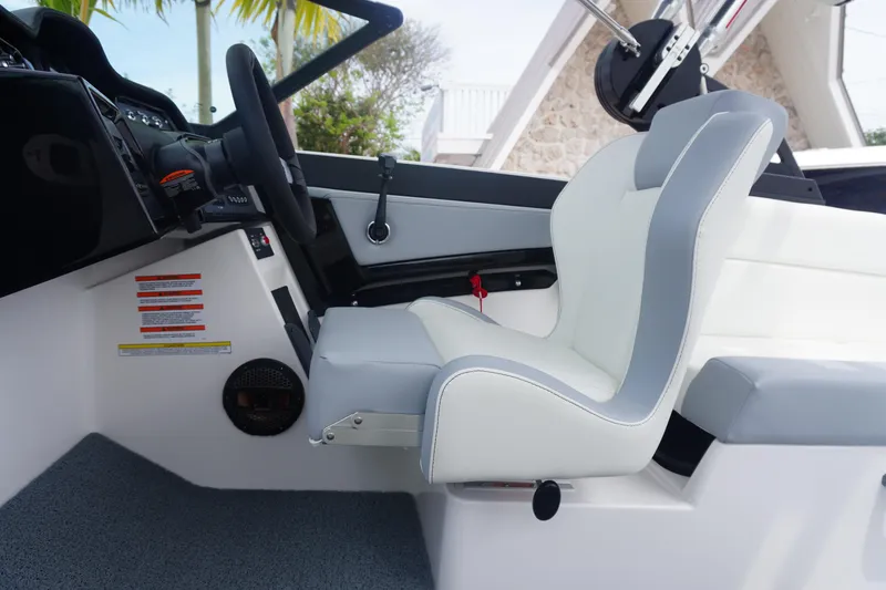 Slide: The Image of 2023 MasterCraft NXT24 boat interior with white and gray seating, steering wheel, and dashboard controls. - 20