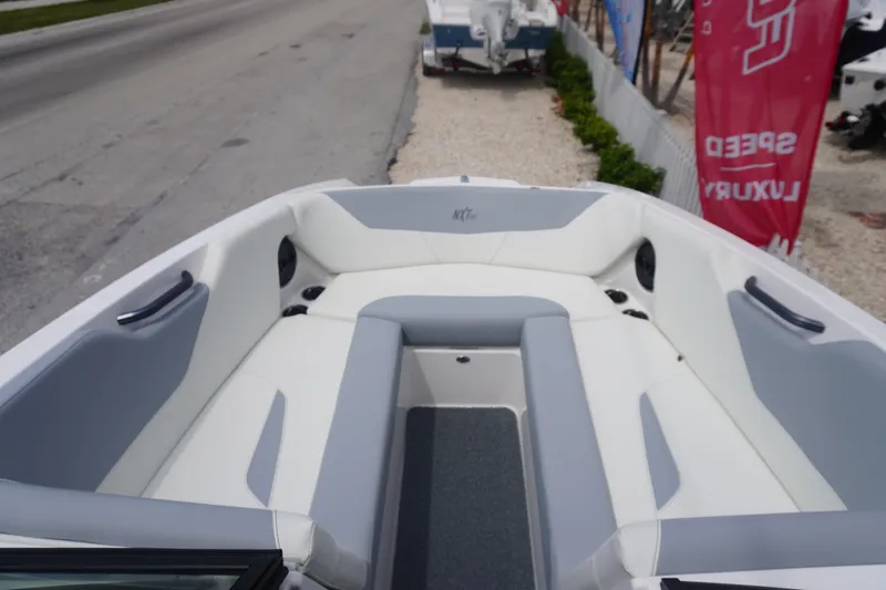 Slide: The Image of 2023 MasterCraft NXT24 boat interior with gray and white seating. - 23