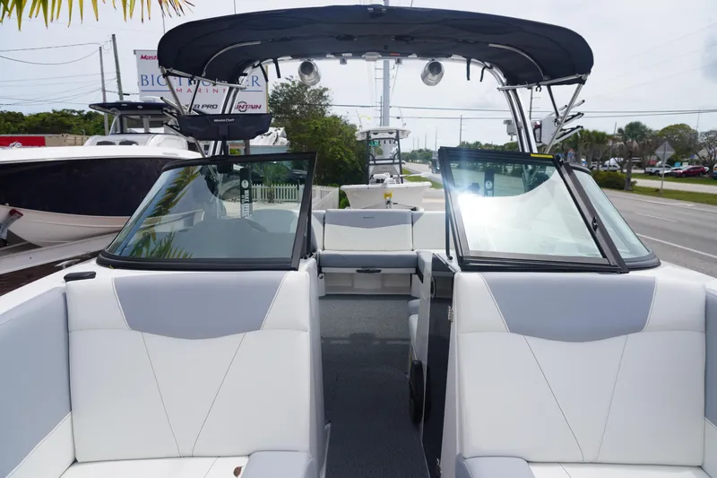 Slide: The Image of 2023 MasterCraft NXT24 boat interior with sleek white seating and black canopy. - 27
