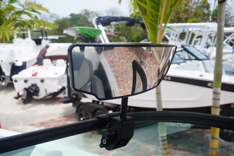 Slide: The Image of 2023 MasterCraft NXT24 boat mirror reflecting nearby boats and palm trees. - 30