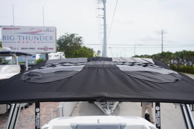 Slide: The Image of 2023 MasterCraft NXT24 boat with black canopy at Big Thunder Marine dealership. - 31