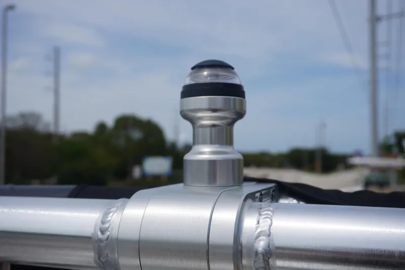 Slide: The Image of Close-up of a 2023 MasterCraft NXT24 boat's metal fixture against a blurred outdoor background. - 32