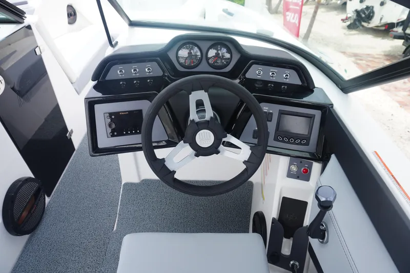 Slide: The Image of 2023 MasterCraft NXT24 boat dashboard with steering wheel and control panels. - 4