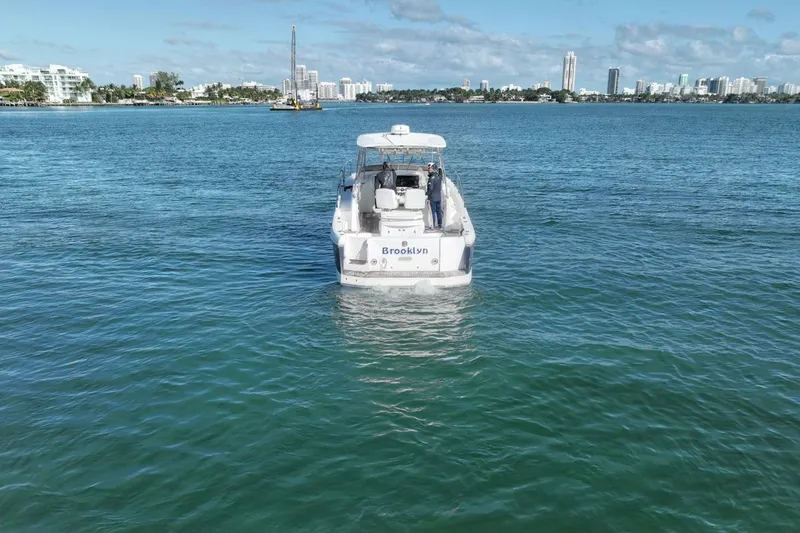 Slide: The Image of 2004 Sunseeker Sportfisher 37 yacht on calm waters with city skyline in background. - 8