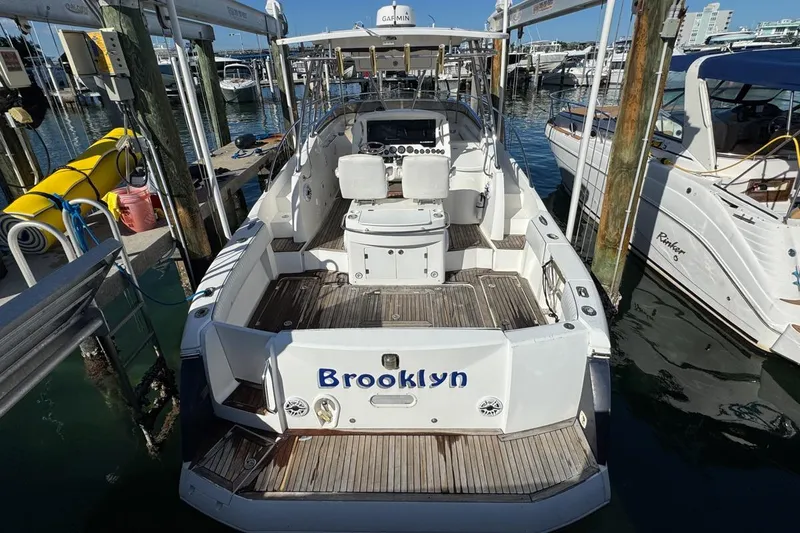 Slide: The Image of 2004 Sunseeker Sportfisher 37 docked, rear view, with "Brooklyn" name on the stern. - 10