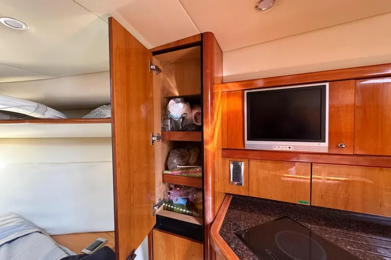 Slide: The Image of Interior of 2004 Sunseeker Sportfisher 37 with wooden cabinetry and TV. - 108