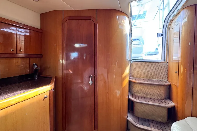 Slide: The Image of Interior of 2004 Sunseeker Sportfisher 37 with wooden cabinetry and curved staircase. - 117