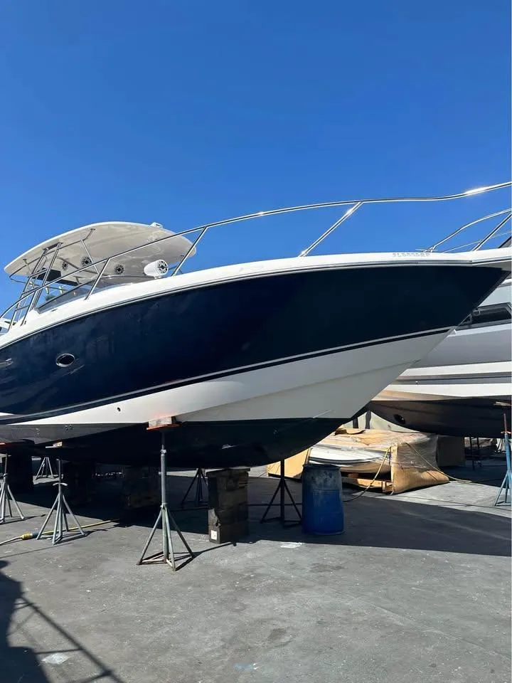 Slide: The Image of 2004 Sunseeker Sportfisher 37 cruising on a sunny day near coastal buildings. - 2