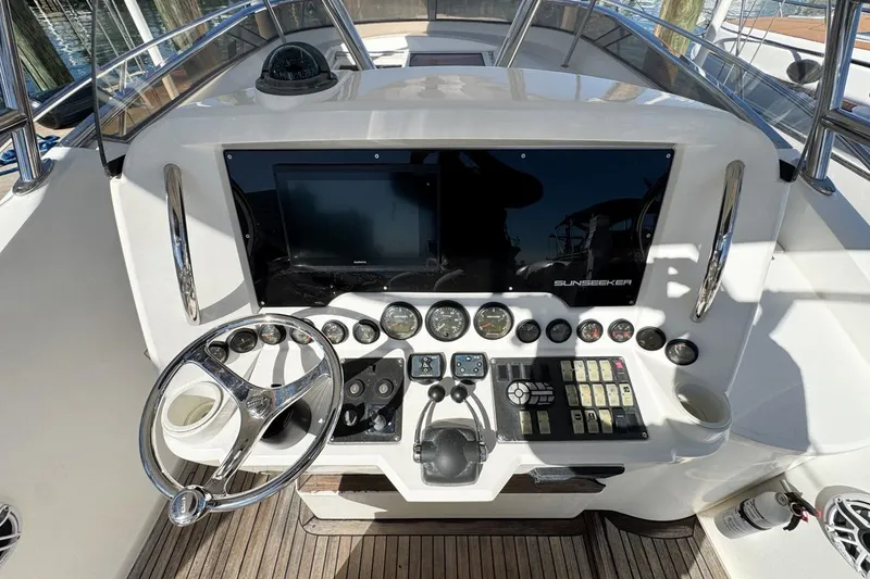 Slide: The Image of Control panel of a 2004 Sunseeker Sportfisher 37 boat, featuring steering wheel and gauges. - 24