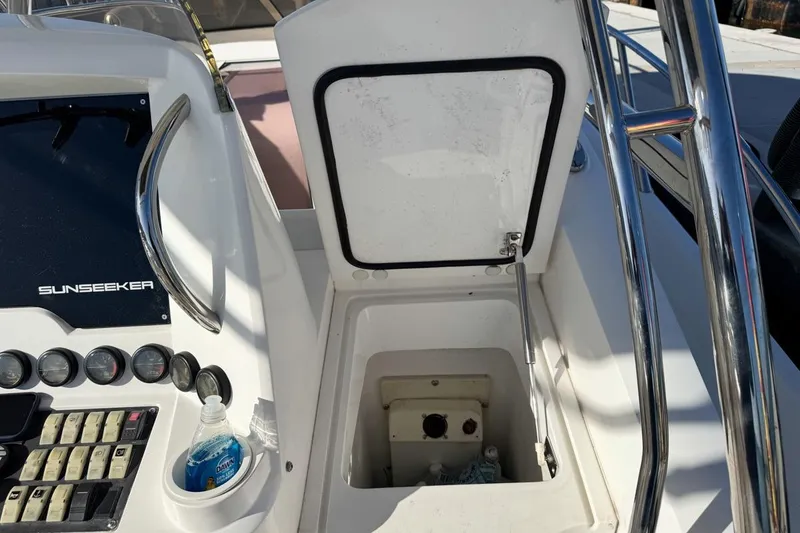 Slide: The Image of 2004 Sunseeker Sportfisher 37 dashboard with open storage compartment and control panel. - 26