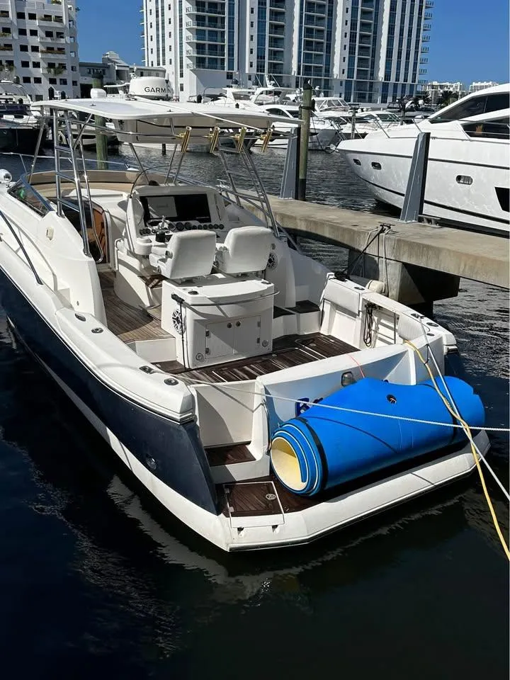 Slide: The Image of 2004 Sunseeker Sportfisher 37 cruising on blue ocean waters near city skyline. - 3