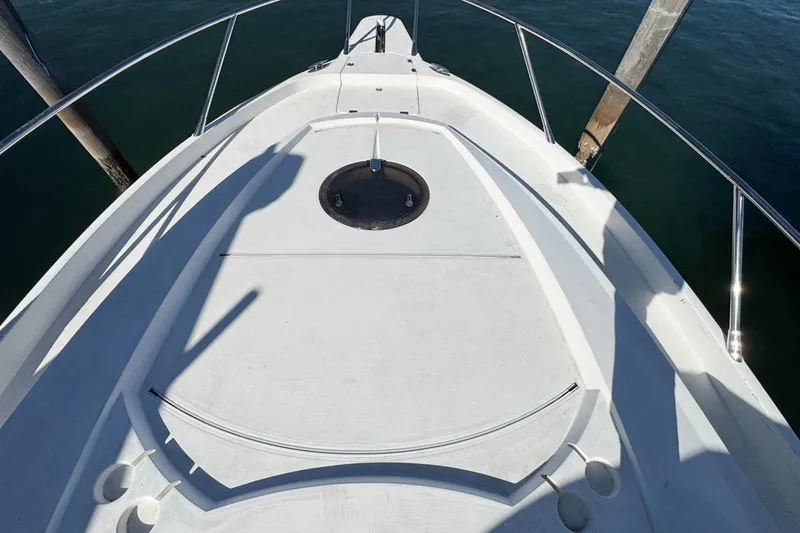 Slide: The Image of 2004 Sunseeker Sportfisher 37 boat deck with railing, docked on calm water. - 46