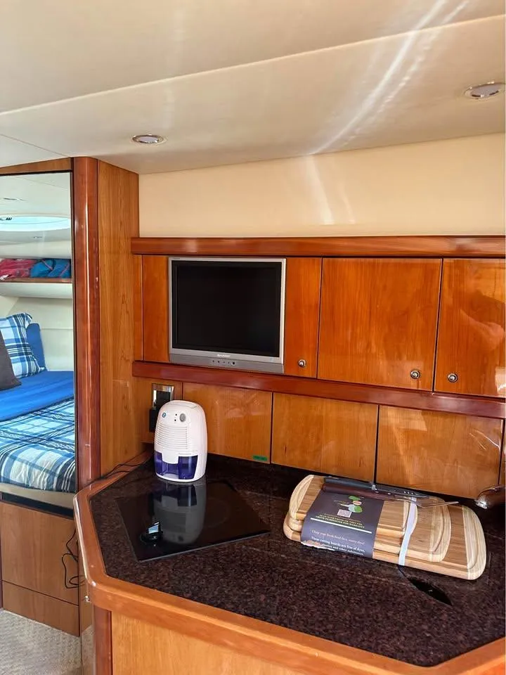 Slide: The Image of 2004 Sunseeker Sportfisher 37 yacht cruising in a marina, clear blue water. - 5