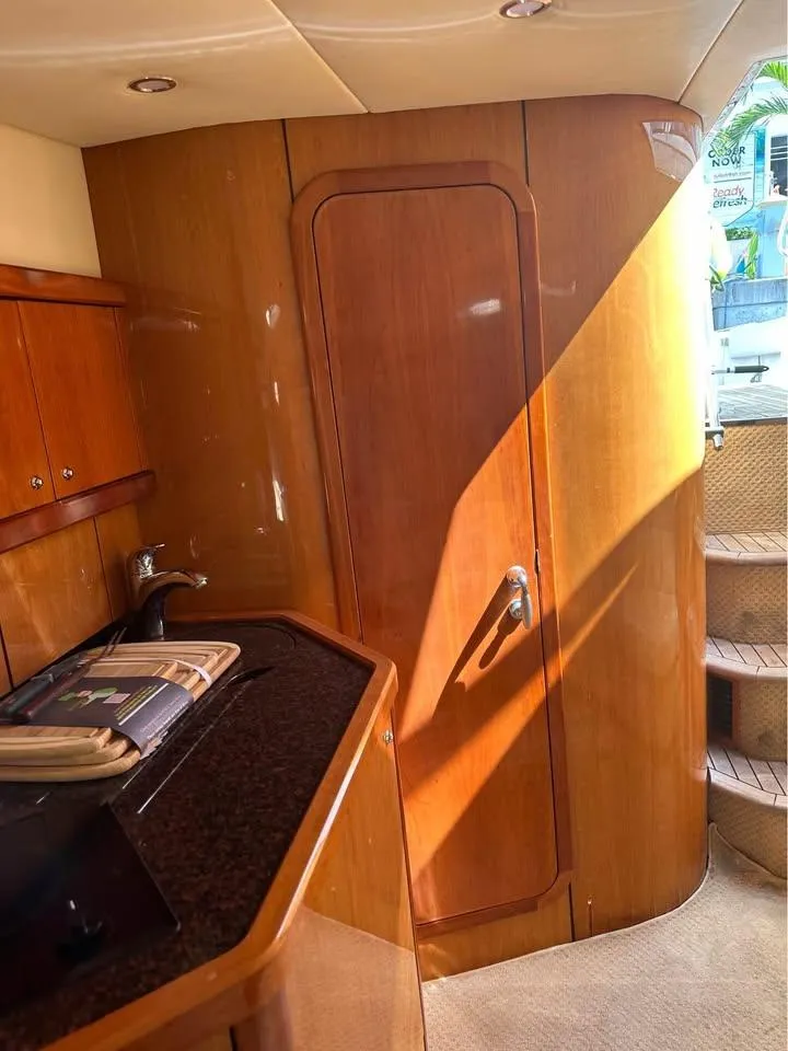 Slide: The Image of 2004 Sunseeker Sportfisher 37 yacht docked in a marina with cityscape backdrop. - 7