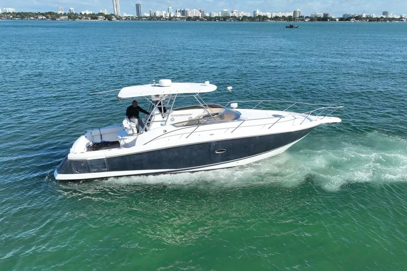 Slide: The Image of 2004 Sunseeker Sportfisher 37 cruising on blue ocean waters near city skyline. - 3