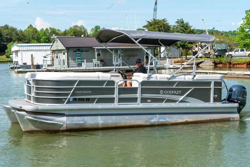 Slide: The Image of 2023 Godfrey Sweetwater 2186 C pontoon boat on a calm lake. - 3