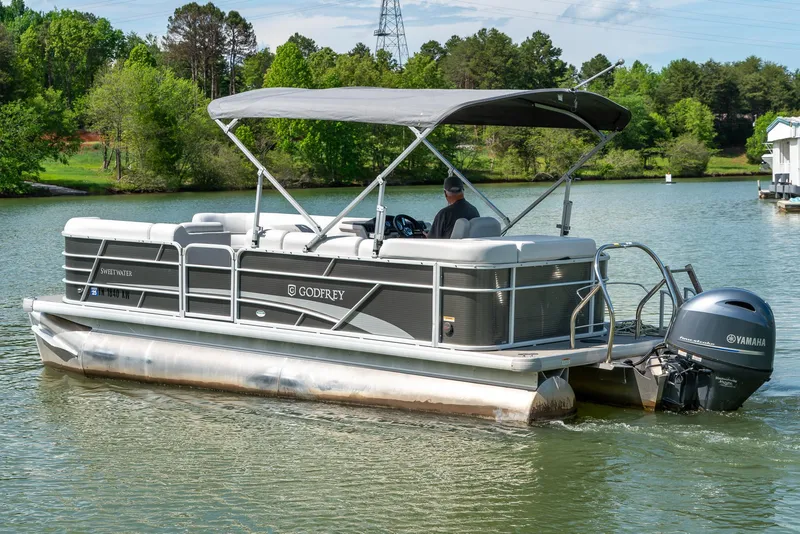 Slide: The Image of 2023 Godfrey Sweetwater 2186 C pontoon boat cruising on a scenic lake. - 4