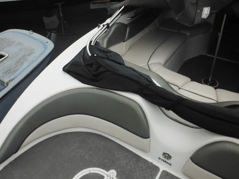 Slide: The Image of 2008 Yamaha Boats SX210 interior with gray and white seating, partially covered. - 16