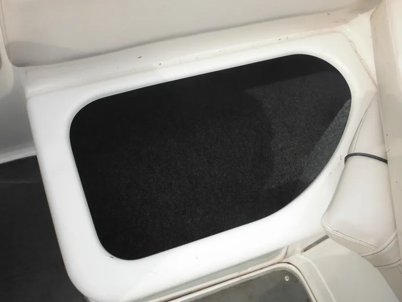 Slide: The Image of Storage compartment in a 2008 Yamaha SX210 boat, featuring a black interior. - 32