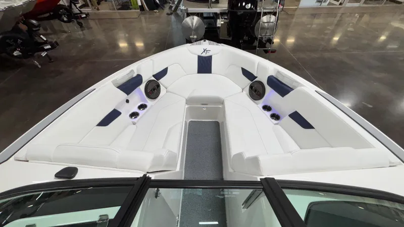 Slide: The Image of 2025 MasterCraft XT23 boat interior with white seating and built-in speakers. - 12