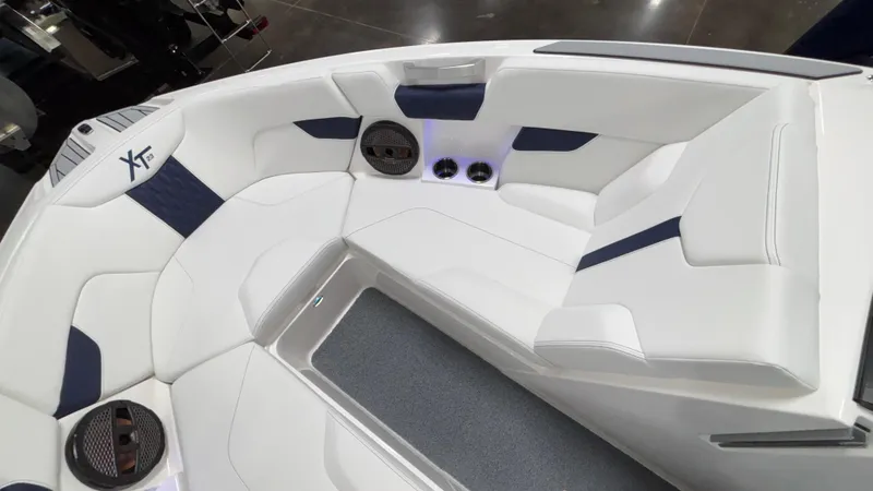 Slide: The Image of 2025 MasterCraft XT23 boat interior with white and navy seating, featuring built-in speakers. - 14