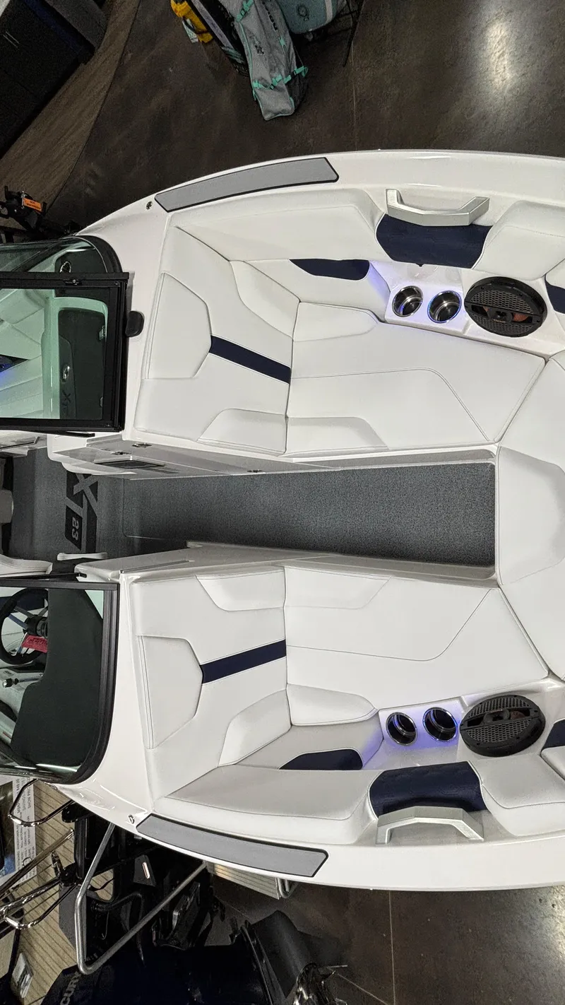Slide: The Image of 2025 MasterCraft XT23 boat interior with white seating and built-in speakers. - 15