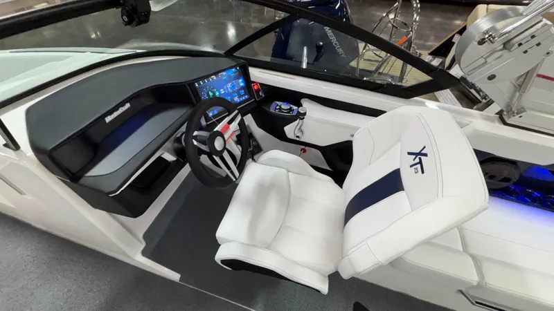 Slide: The Image of 2025 MasterCraft XT23 boat interior with modern dashboard and white seating. - 18