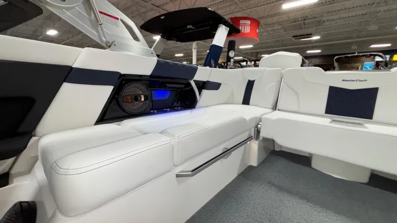 Slide: The Image of 2025 MasterCraft XT23 boat interior with white seating and built-in speaker system. - 20