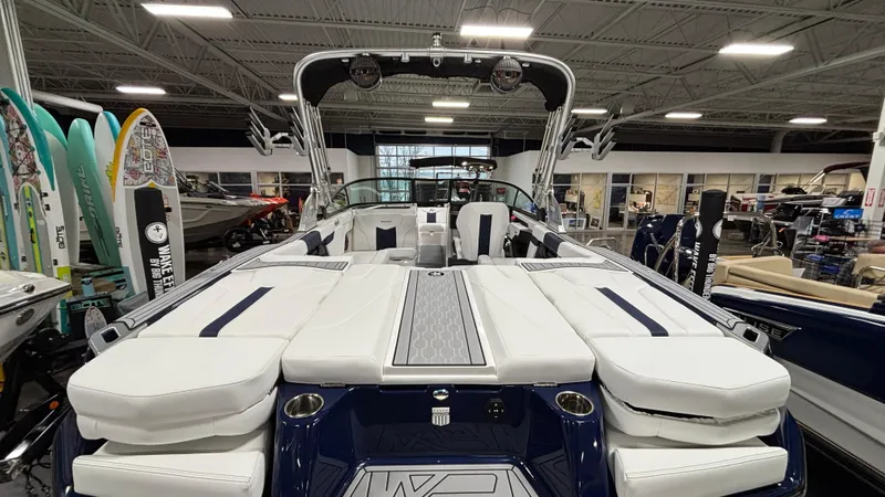 Slide: The Image of 2025 MasterCraft XT23 boat interior with white seating, showcased in a showroom. - 29