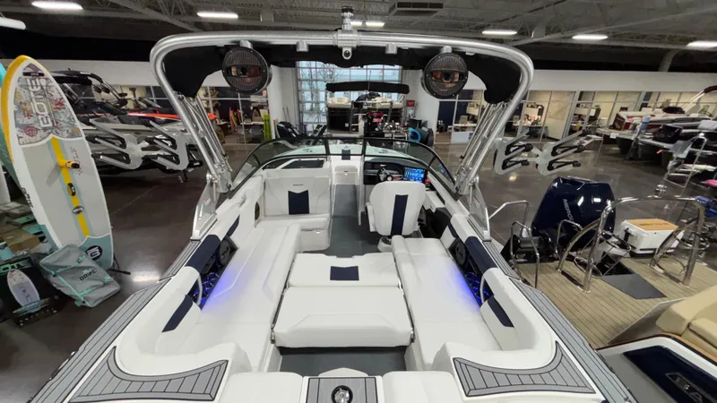 Slide: The Image of 2025 MasterCraft XT23 boat interior with luxurious seating and modern design in showroom. - 30