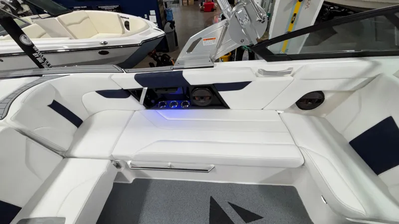 Slide: The Image of 2025 MasterCraft XT23 boat interior with white and navy seating, modern design, and audio system. - 8