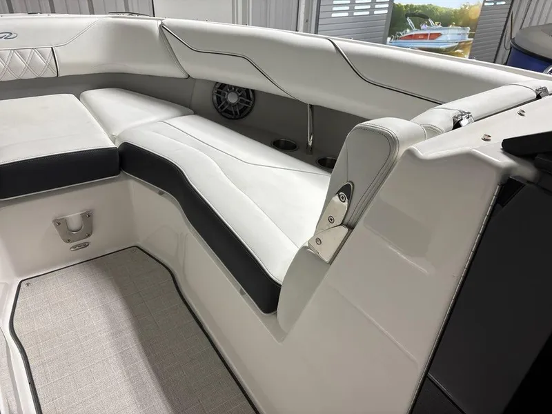 Slide: The Image of 2026 Regal LX4 boat interior with white and black seating, cup holders, and speaker. - 11