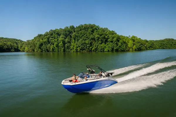 Slide: The Image of 2025 Yamaha AR250 boat cruising on a serene lake with lush green trees. - 1