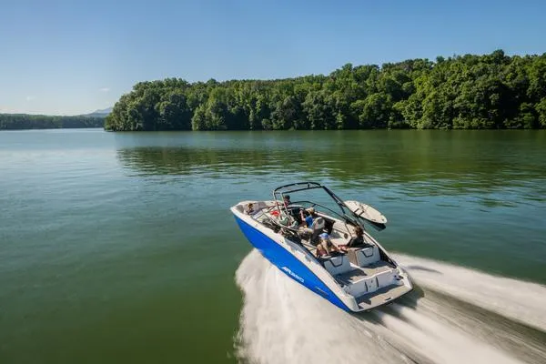 Slide: The Image of 2025 Yamaha Boats AR250 speeding on a serene lake with lush green forest backdrop. - 7