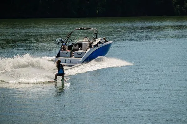 Slide: The Image of 2025 Yamaha Boats AR250 towing a wakeboarder on a sunny lake. - 8