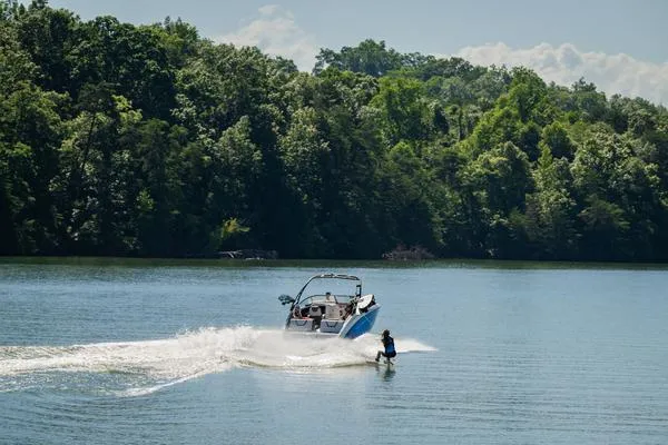 Slide: The Image of 2025 Yamaha AR250 boat towing a wakeboarder on a scenic lake. - 9