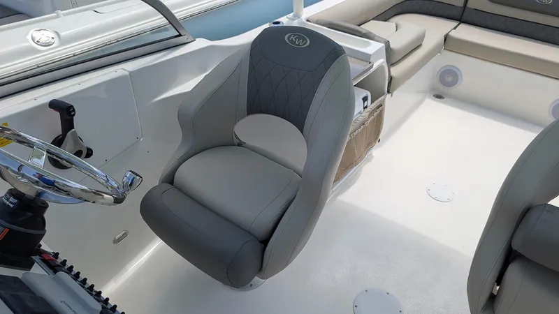 Slide: The Image of 2025 Key West 239 DFS boat interior with gray captain's chair and steering wheel. - 10