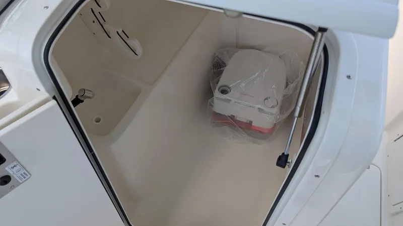 Slide: The Image of 2025 Key West 239 DFS boat interior storage compartment with portable toilet. - 13