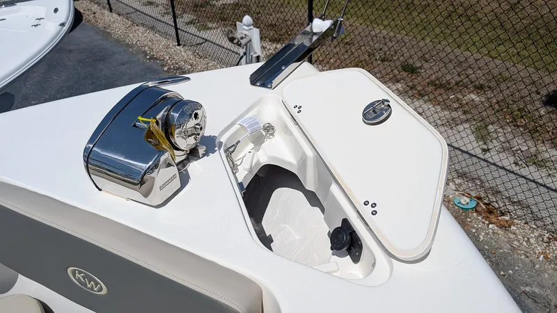 Slide: The Image of 2025 Key West 239 DFS boat anchor compartment with chrome winch and open hatch. - 16