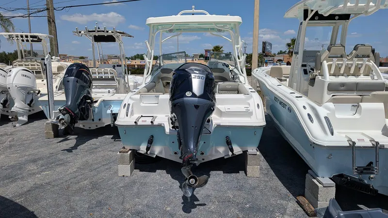 Slide: The Image of 2025 Key West 239 DFS boat with outboard motor, displayed in a marina setting. - 2