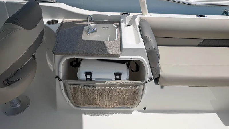 Slide: The Image of 2025 Key West 239 DFS boat interior with sink, storage, and seating area. - 7