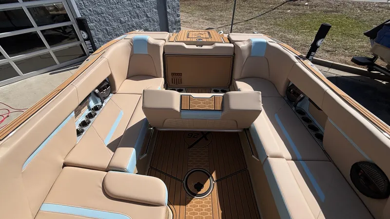 Slide: The Image of 2025 MasterCraft X26 boat interior with beige seating and wood flooring. - 12