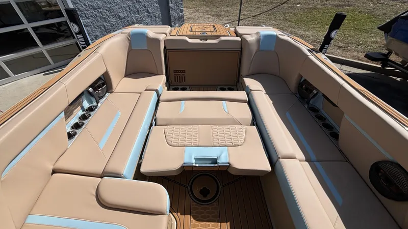 Slide: The Image of 2025 MasterCraft X26 boat interior with beige and blue seating, showcasing luxury and comfort. - 13