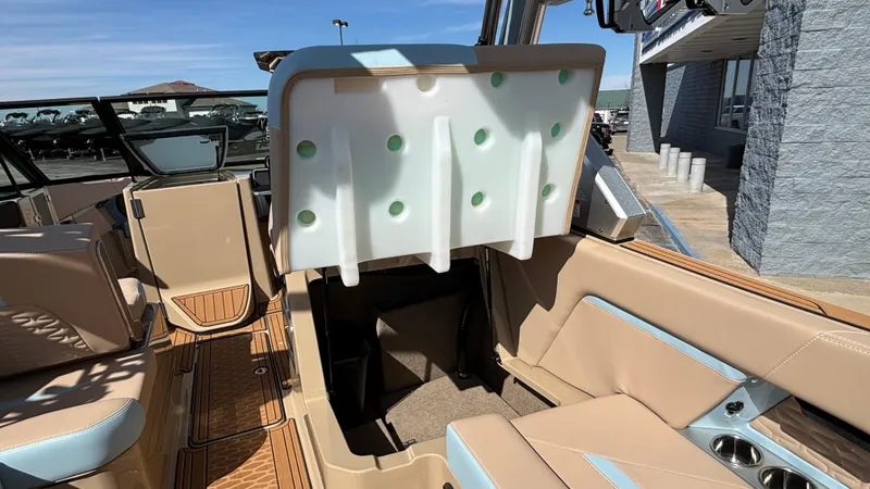 Slide: The Image of 2025 MasterCraft X26 boat interior with beige seating and storage compartment. - 19