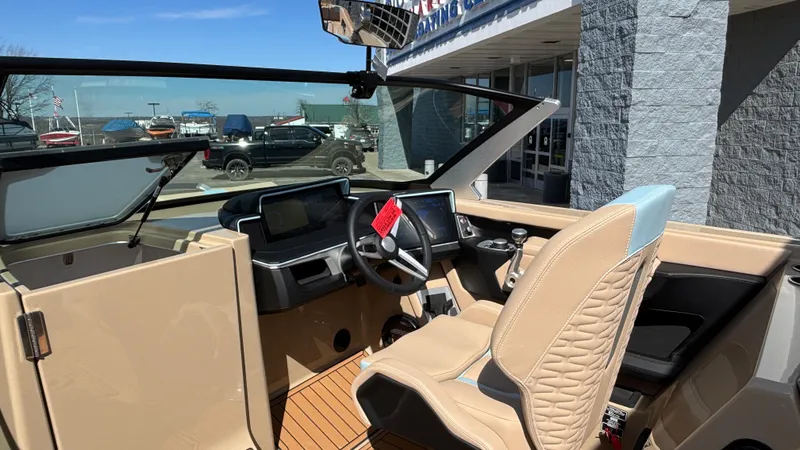Slide: The Image of 2025 MasterCraft X26 boat interior with modern dashboard and beige seating. - 27