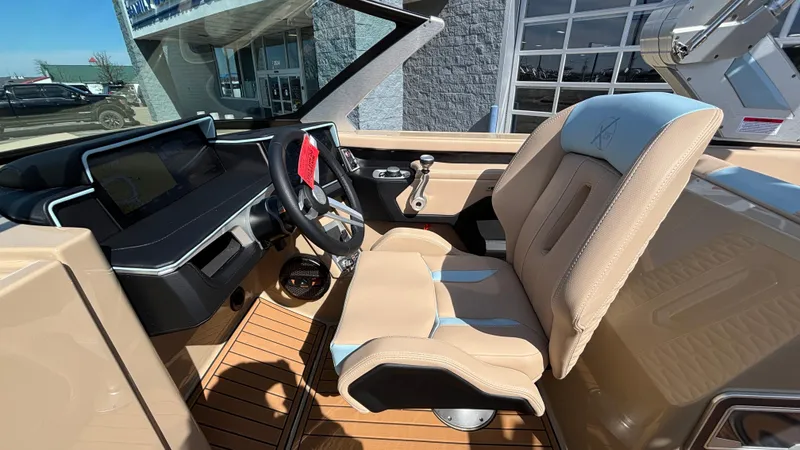 Slide: The Image of 2025 MasterCraft X26 boat interior with beige seating and modern dashboard. - 28