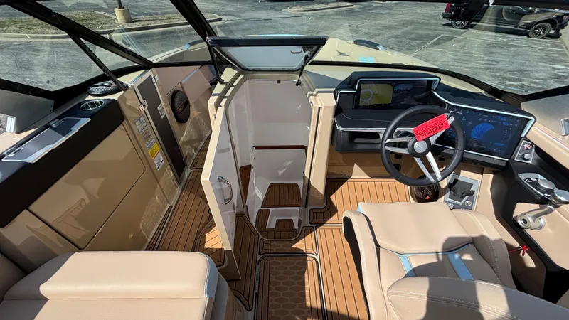 Slide: The Image of 2025 MasterCraft X26 boat interior with modern dashboard and beige seating. - 29