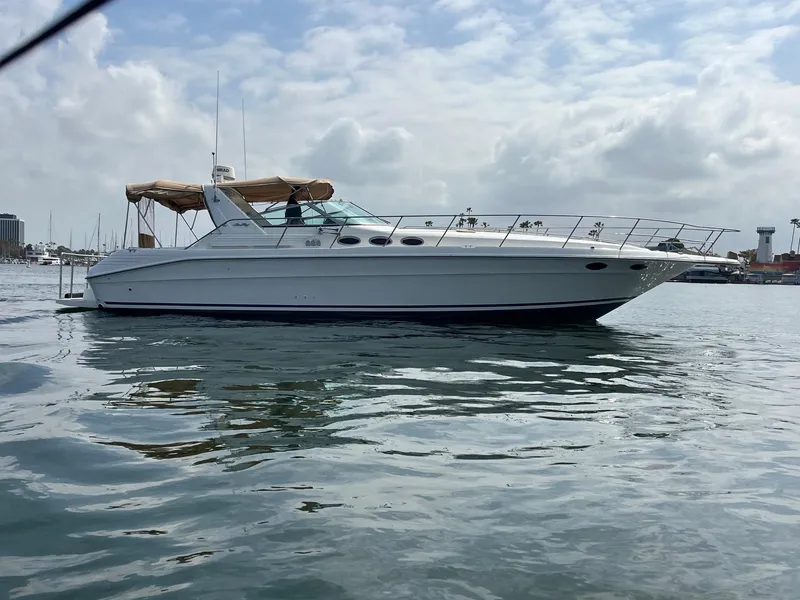 The Image of 1994 Sea Ray 400 Express yacht on calm water under a cloudy sky. - 0
