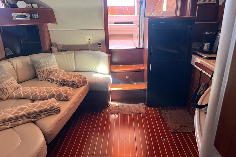 Slide: The Image of Interior of a 1994 Sea Ray 400 Express Cruiser with cozy seating and wooden flooring. - 12