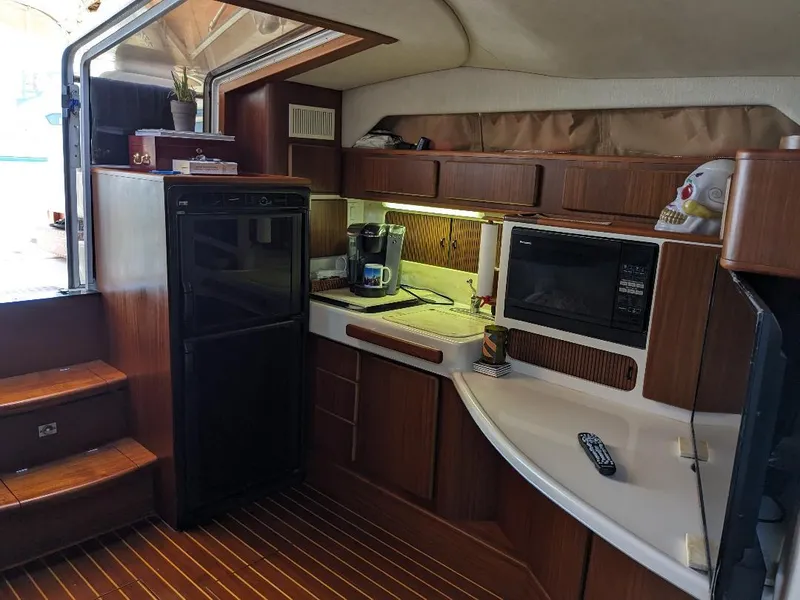 Slide: The Image of Interior of 1994 Sea Ray 400 Express yacht with kitchenette, microwave, and wooden cabinetry. - 14